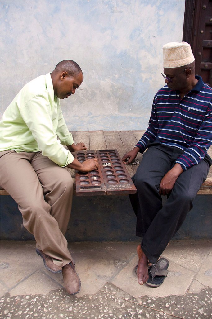 Two local men playing the traditional game of Bao - Stone Town Travel Guide