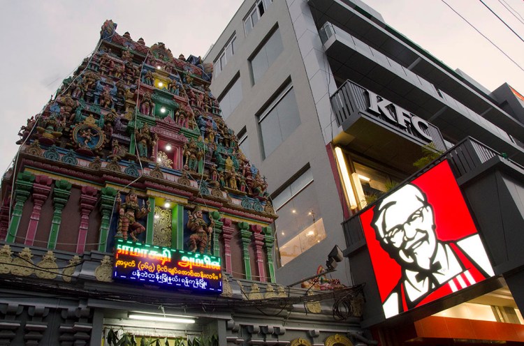 A KFC sign clashes with a Hindu temple spire.