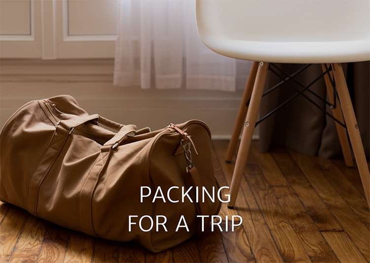 Brown leather duffel and white chair - Link to Packing for a trip