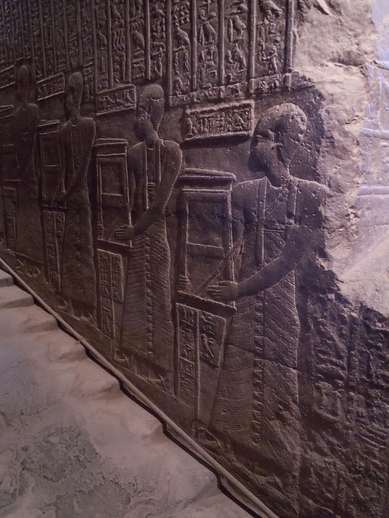 Relief on opposite wall of priests  ascending the  procession staircase.

