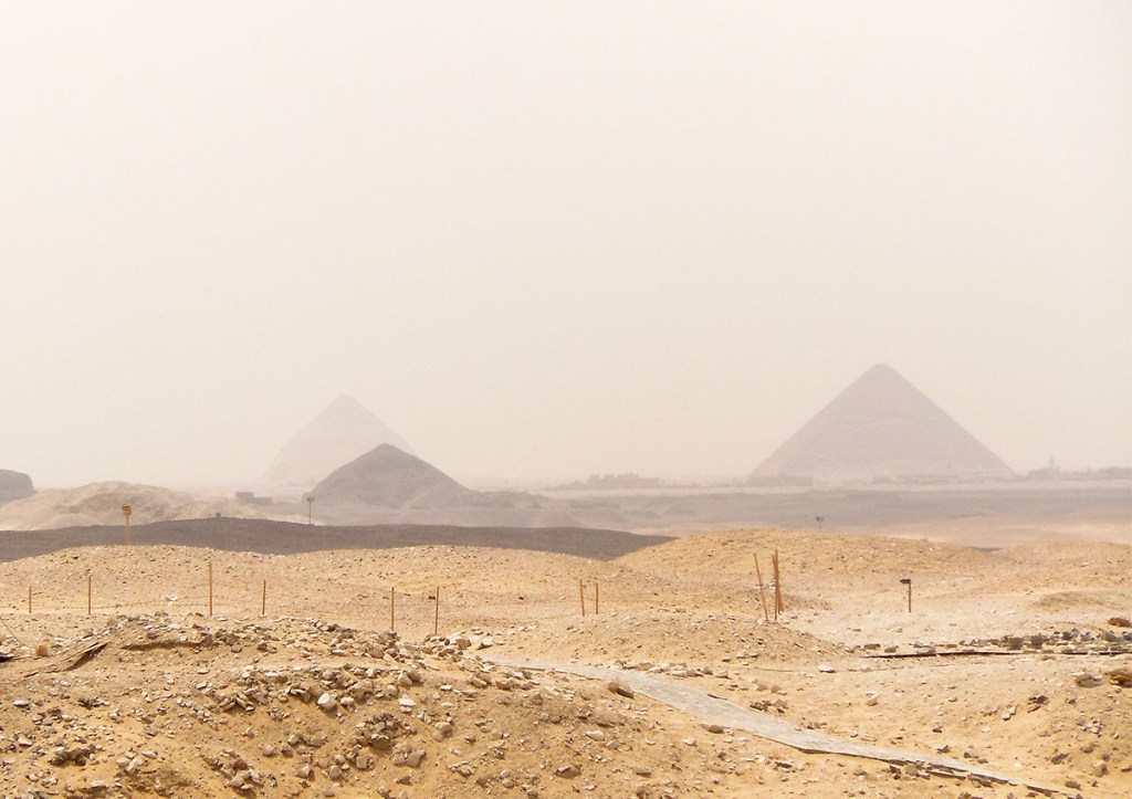 Hazy view of the Bent Pyramid and all the way to the Pyramids of Giza from high above the Red Pyramid.