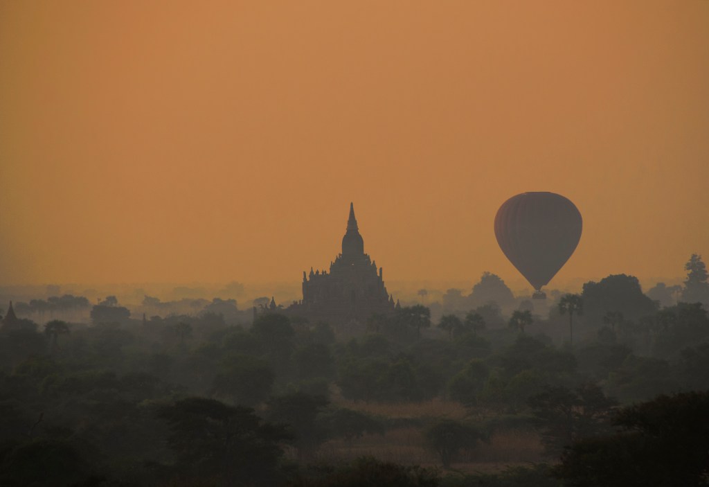 Dawn silhouttes of a balloon and pagoda viewed from the top pf Pyathatgyi) stupa.