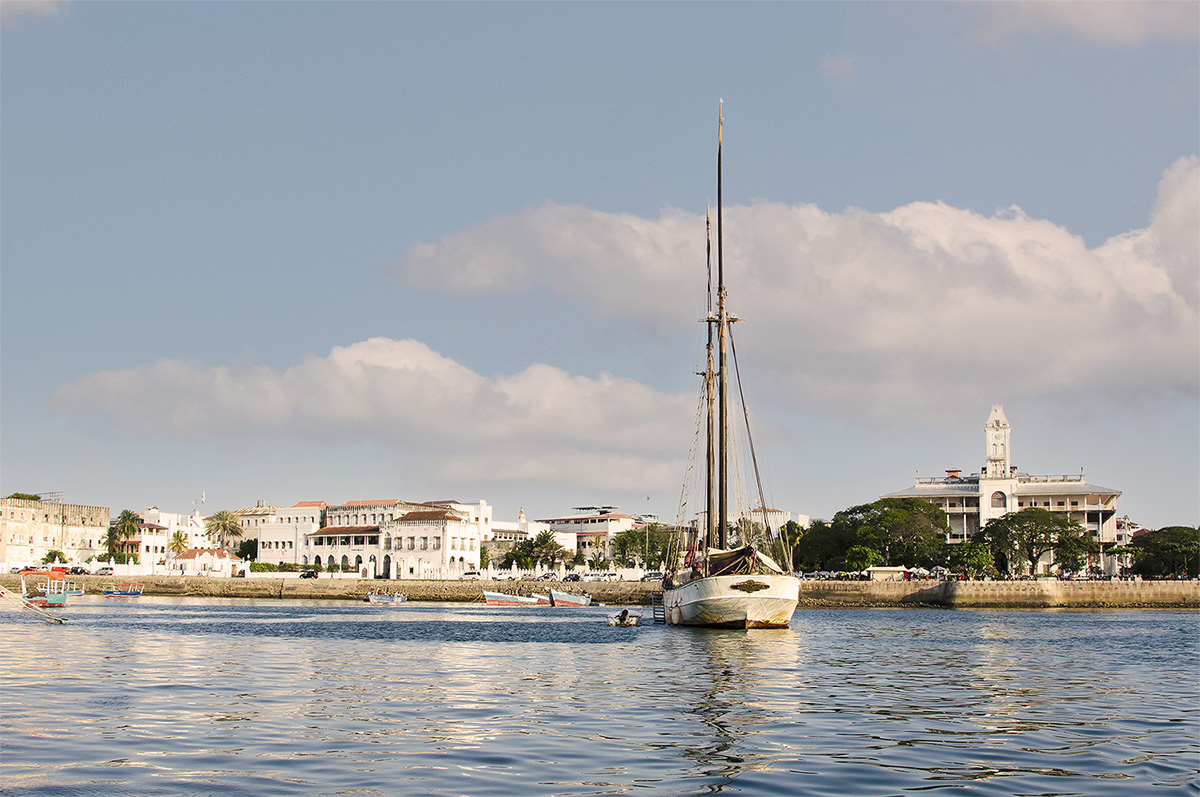 View of the Stone Town waterfront from our boat. The Palace of Wonders is on the right and the Palace museum to the left of the dhow - Stone Town Travel Guide